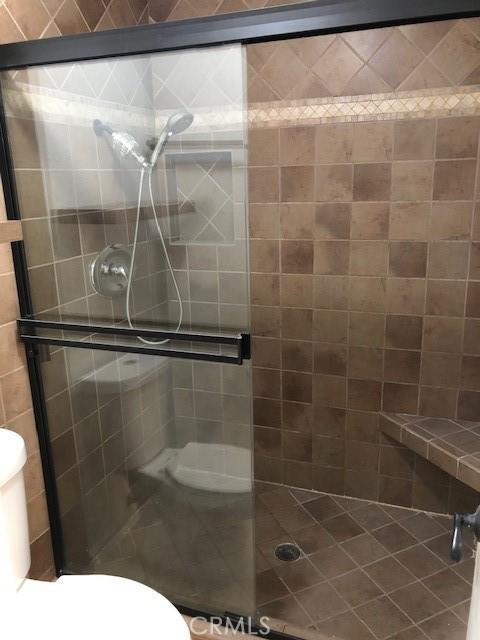 bathroom with a shower stall and toilet