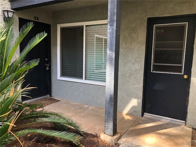 view of exterior entry with stucco siding