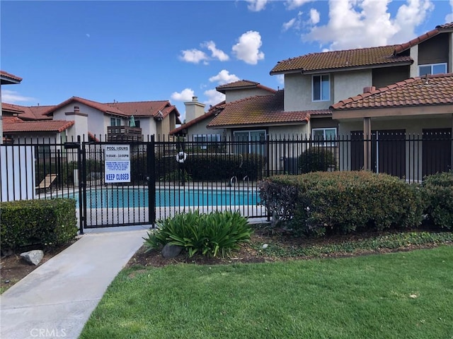 community pool featuring a yard and fence