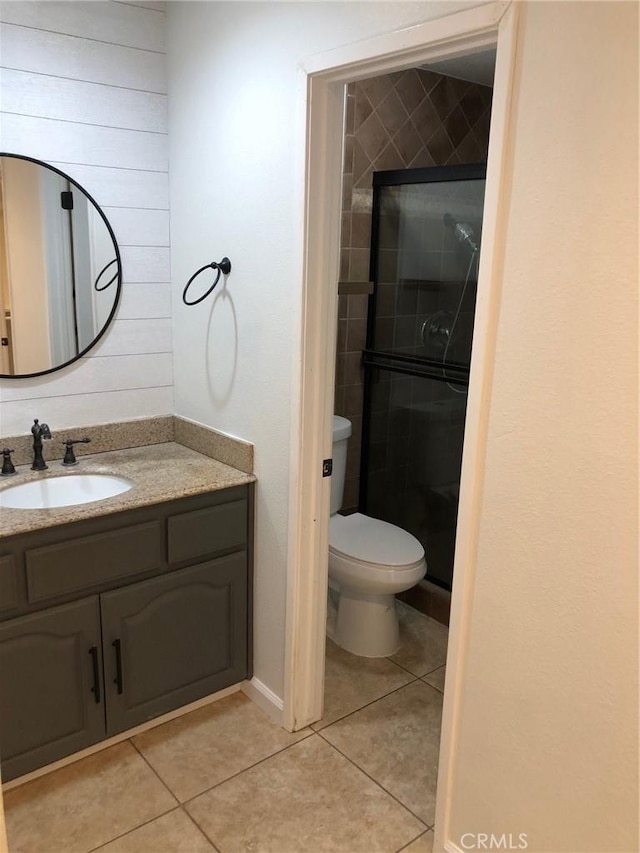 full bathroom with toilet, a stall shower, tile patterned flooring, and vanity