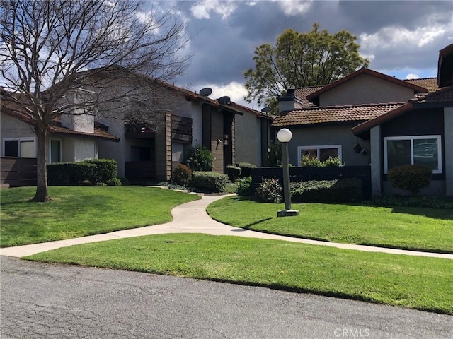 view of front of house with a front lawn and stucco siding