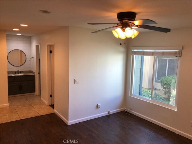 unfurnished room with recessed lighting, ceiling fan, a sink, wood finished floors, and baseboards