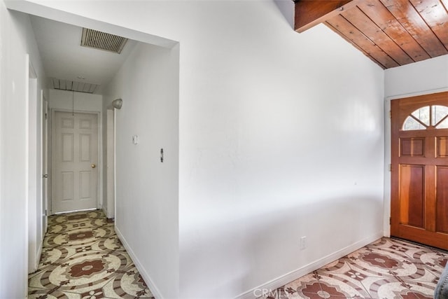 foyer entrance with lofted ceiling with beams, visible vents, and baseboards