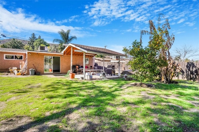 back of house with a yard, a patio area, and a fenced backyard