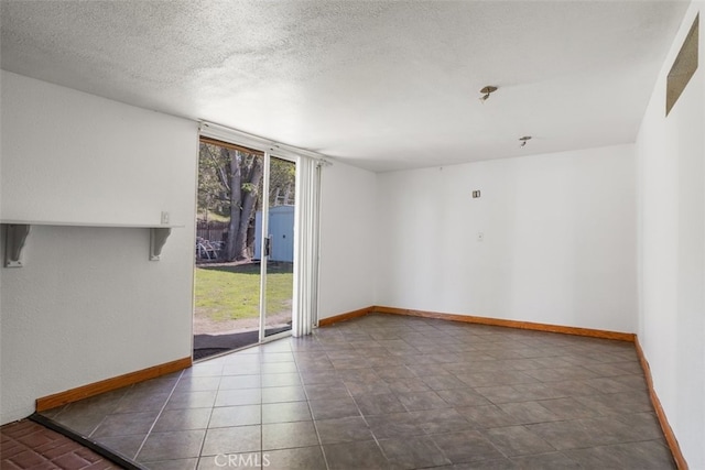 empty room featuring a wall of windows, a textured ceiling, and baseboards