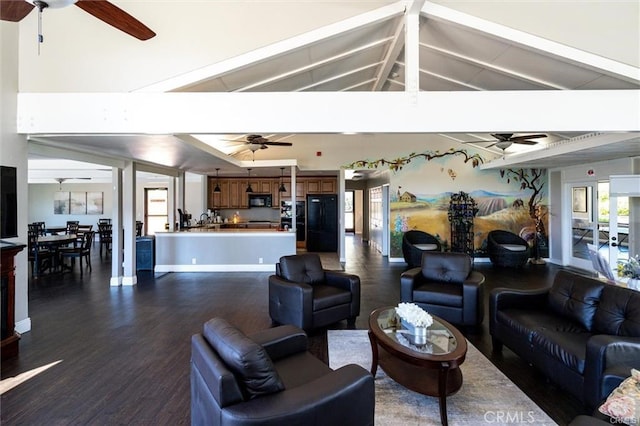 living room featuring ceiling fan, lofted ceiling with beams, and dark wood-style flooring