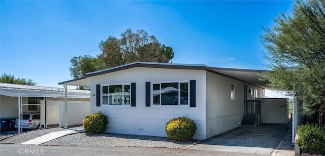 manufactured / mobile home featuring crawl space, driveway, and an attached carport