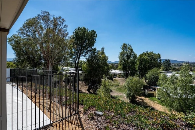 view of yard featuring fence and a mountain view