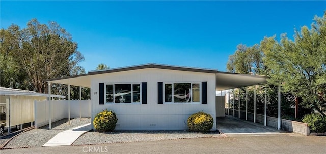 view of property exterior featuring a carport, crawl space, fence, and driveway