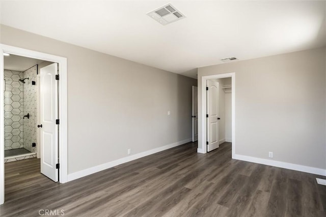 unfurnished bedroom with baseboards, visible vents, and dark wood finished floors