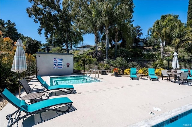 view of pool with a swimming pool, fence, and a patio