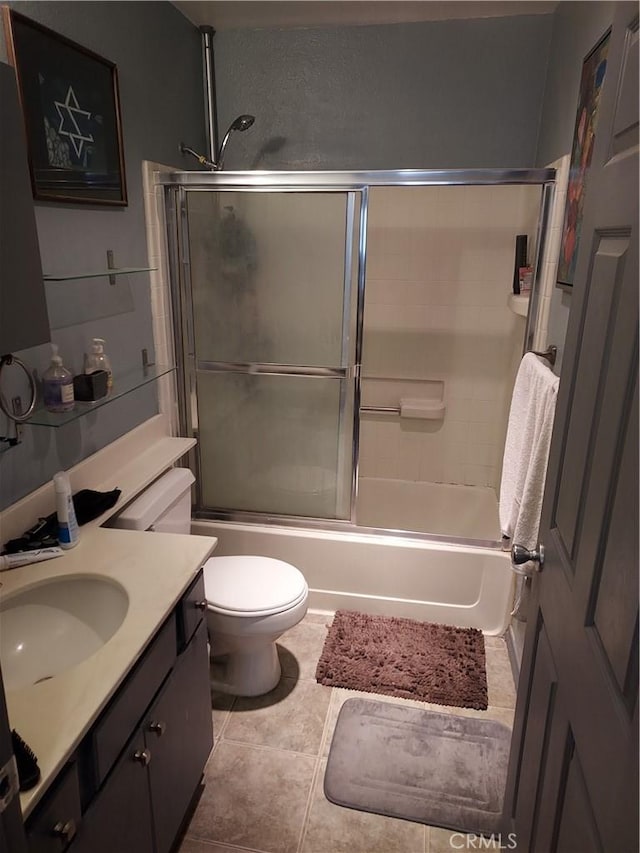 full bathroom with toilet, shower / bath combination with glass door, tile patterned floors, and vanity