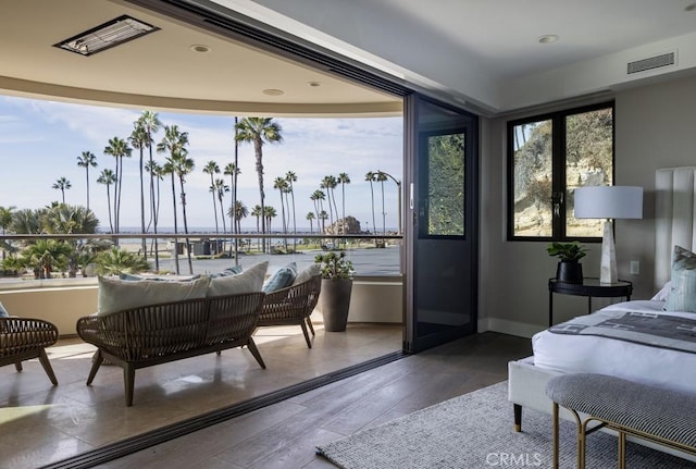 bedroom with multiple windows, wood finished floors, visible vents, and baseboards