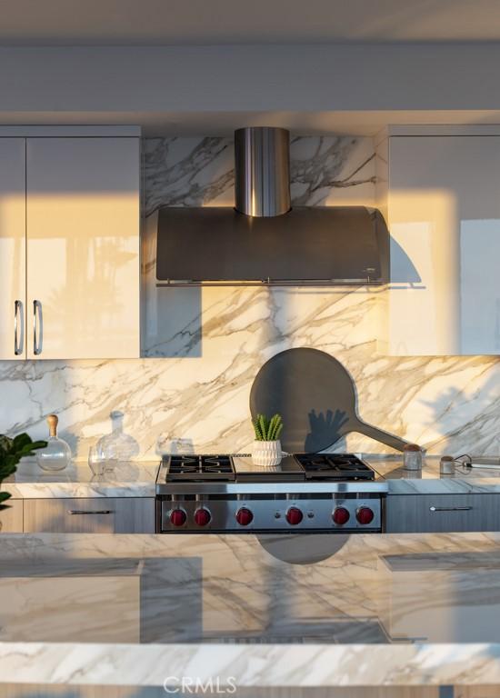 kitchen featuring ventilation hood, stone countertops, and decorative backsplash