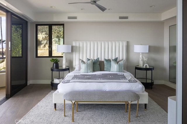 bedroom featuring baseboards, visible vents, and wood finished floors