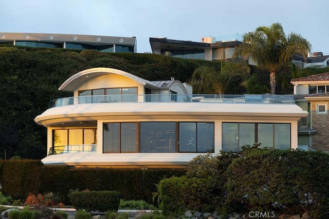 rear view of property featuring a balcony and stucco siding