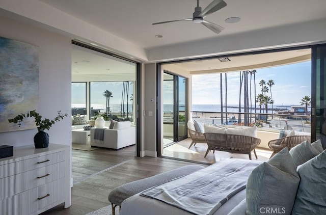 bedroom featuring access to outside, multiple windows, and wood finished floors