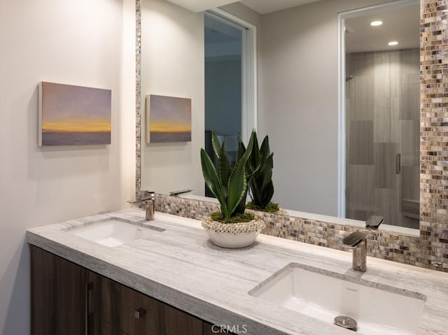 bathroom with recessed lighting, a sink, a shower stall, and double vanity