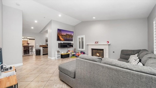 living area featuring a fireplace, lofted ceiling, recessed lighting, light tile patterned flooring, and baseboards