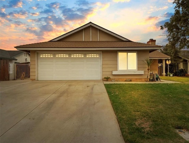 ranch-style home featuring concrete driveway, an attached garage, a chimney, and a front lawn