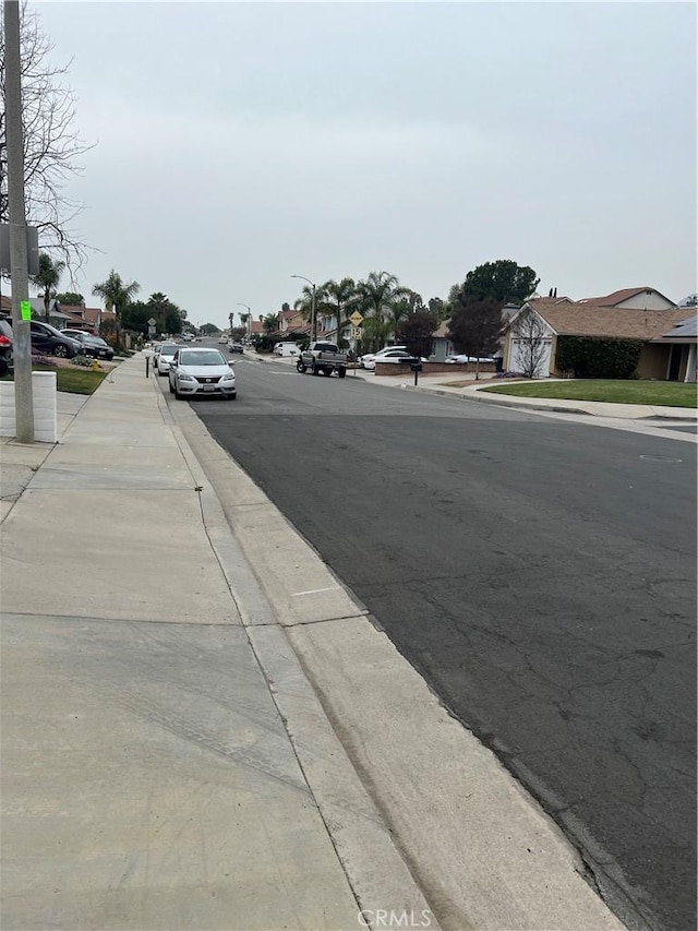 view of road with sidewalks, street lighting, and curbs