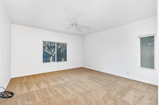 unfurnished room with carpet, baseboards, and a ceiling fan