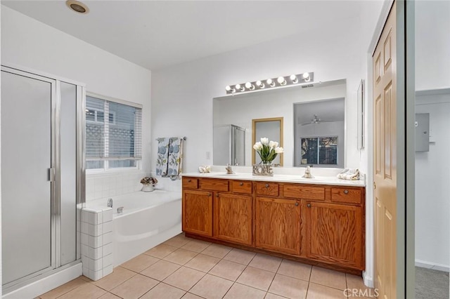 bathroom featuring a garden tub, tile patterned flooring, a sink, a shower stall, and double vanity