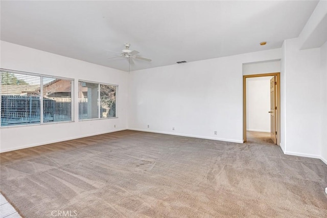 spare room featuring carpet, visible vents, ceiling fan, and baseboards