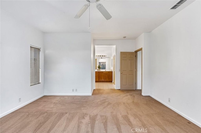 unfurnished room featuring light carpet, baseboards, visible vents, and ceiling fan