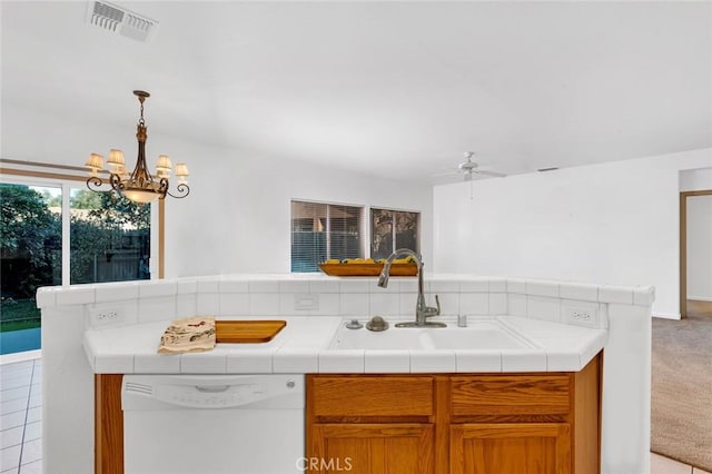 kitchen featuring visible vents, light colored carpet, white dishwasher, a sink, and ceiling fan with notable chandelier