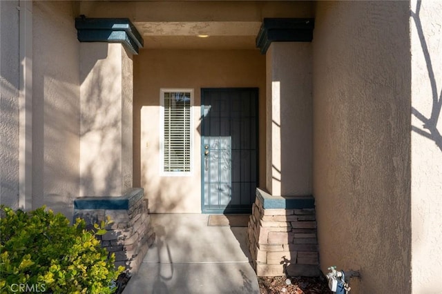 view of exterior entry with stucco siding