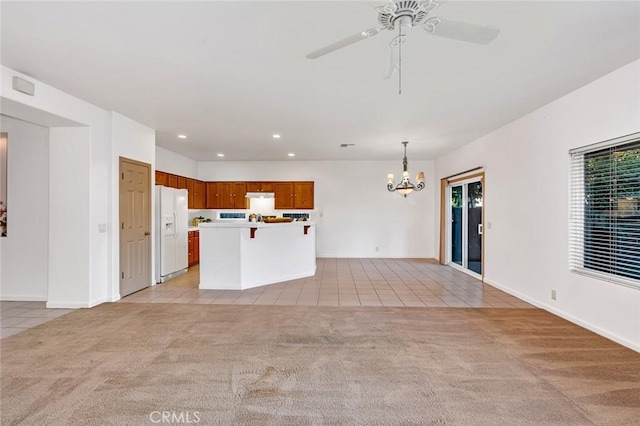 unfurnished living room featuring light tile patterned floors, recessed lighting, plenty of natural light, and light colored carpet