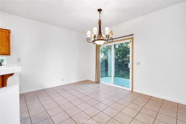 unfurnished dining area with a chandelier and baseboards