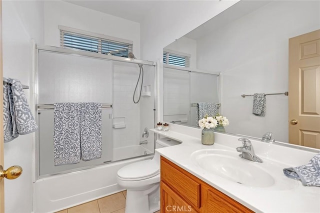 full bathroom featuring toilet, tile patterned floors, bath / shower combo with glass door, and vanity