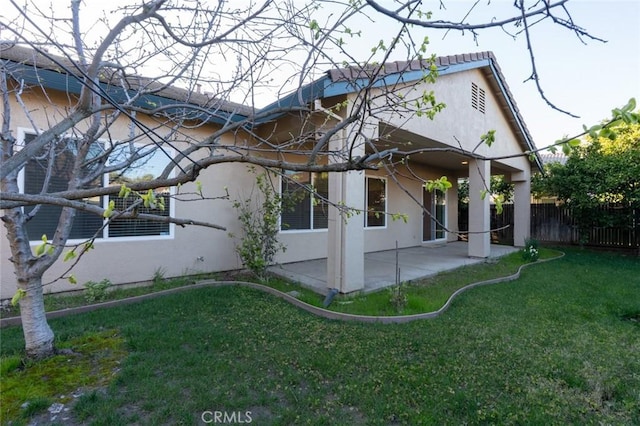 exterior space with a yard, a patio area, fence, and stucco siding