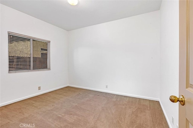 carpeted spare room featuring baseboards