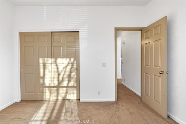 unfurnished bedroom featuring carpet, a closet, and baseboards