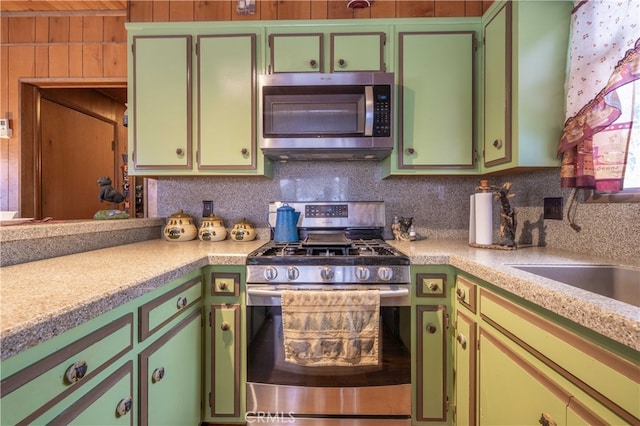 kitchen featuring appliances with stainless steel finishes, decorative backsplash, and light countertops