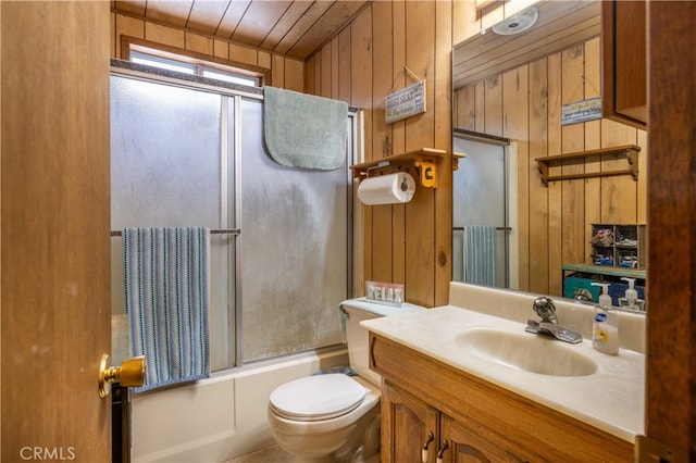 full bath featuring toilet, wooden walls, enclosed tub / shower combo, and vanity