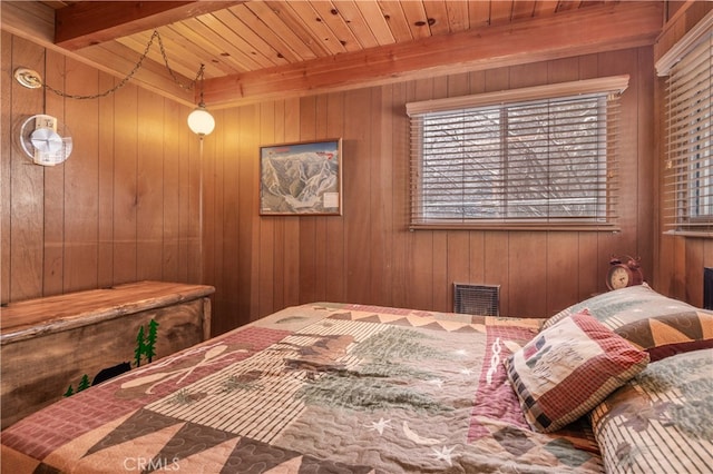 bedroom featuring beamed ceiling, visible vents, and wooden walls