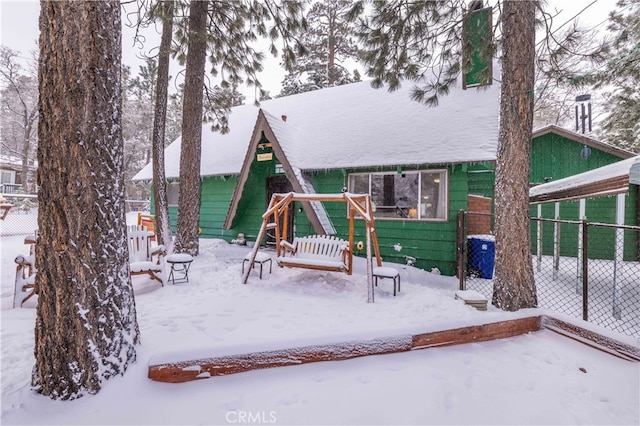 snow covered playground featuring fence