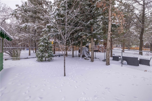 yard covered in snow featuring fence