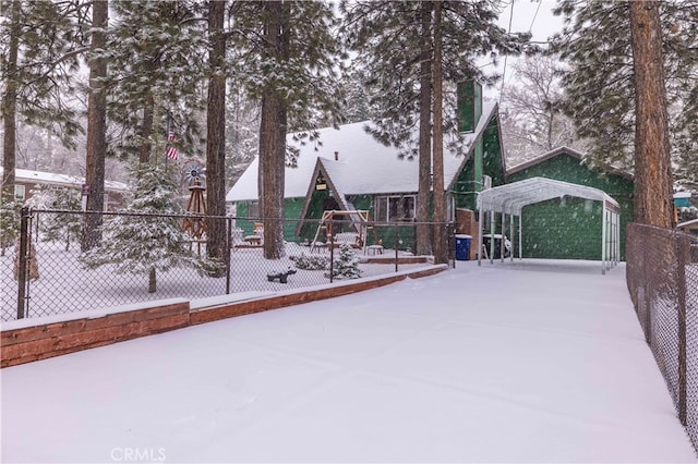 exterior space featuring fence, a playground, and a detached carport