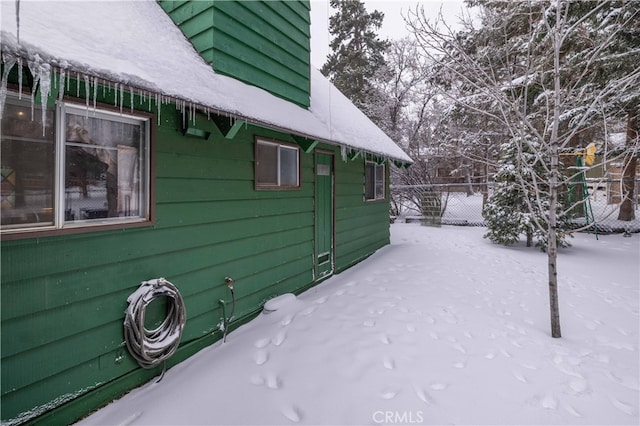 view of snowy exterior with fence