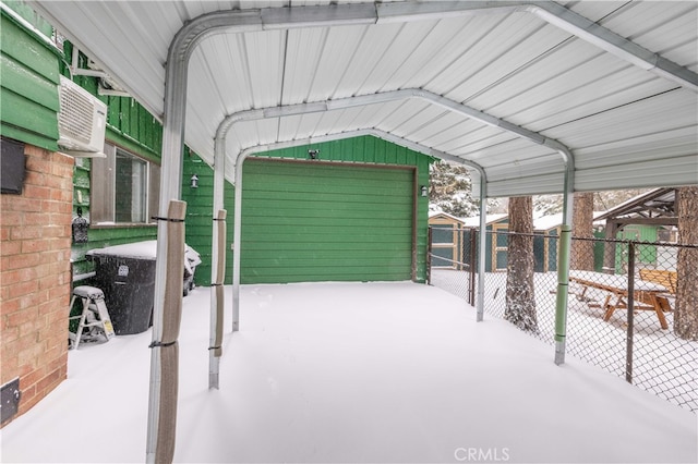 snow covered garage featuring cooling unit and fence