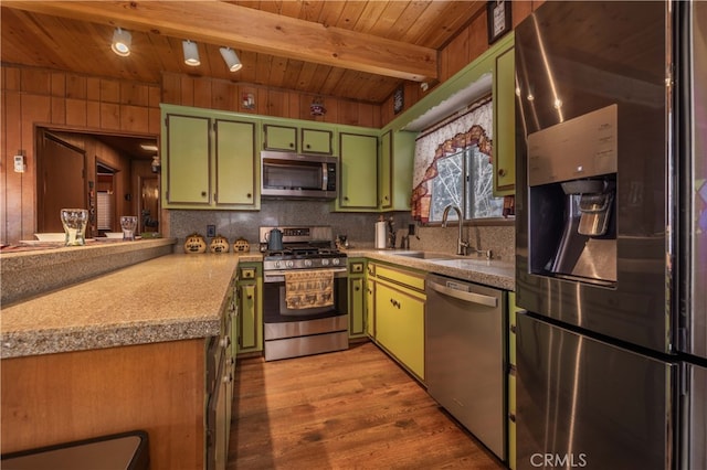 kitchen featuring green cabinetry, wooden ceiling, appliances with stainless steel finishes, beam ceiling, and a sink