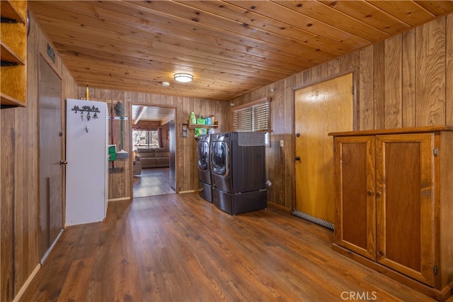 laundry room with wooden walls, laundry area, wood ceiling, dark wood-style floors, and washing machine and clothes dryer