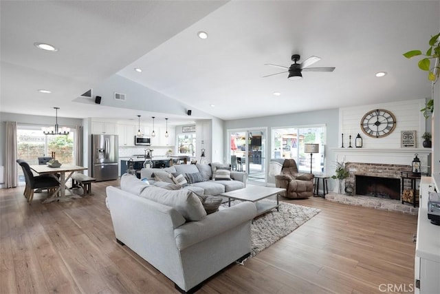 living room featuring a wealth of natural light, visible vents, wood finished floors, and a fireplace