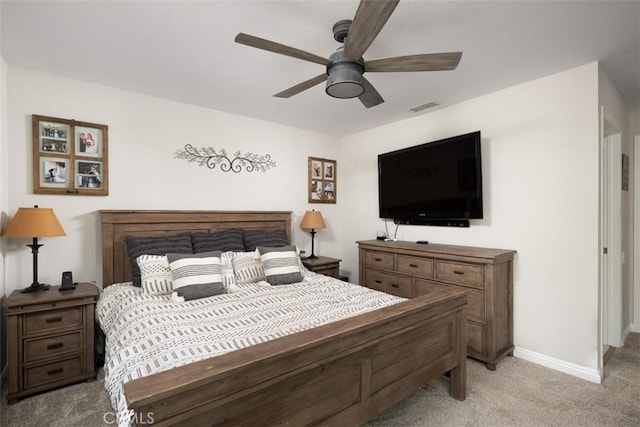 bedroom with visible vents, light carpet, baseboards, and a ceiling fan