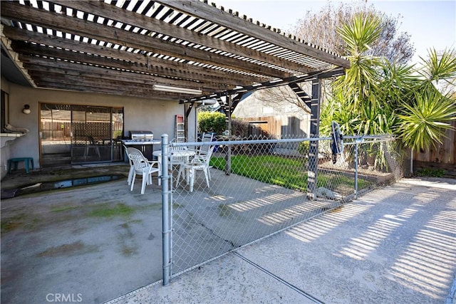 view of patio with outdoor dining area, fence, and a gate